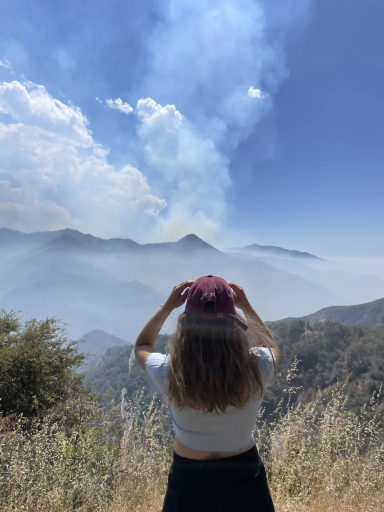 Photo de Maeva Raen de dos, regardant l'horizon en montagne